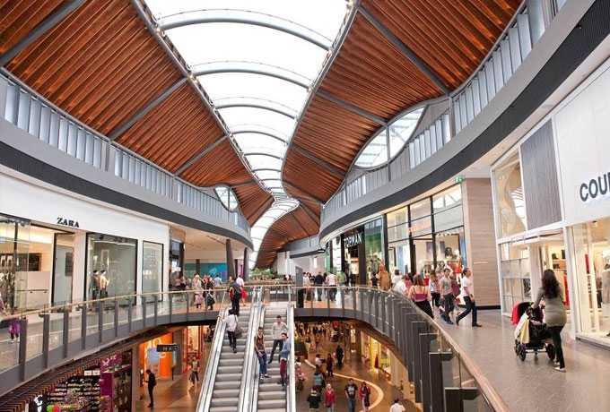 Interior upper-level concourse in a large, modern shopping centre